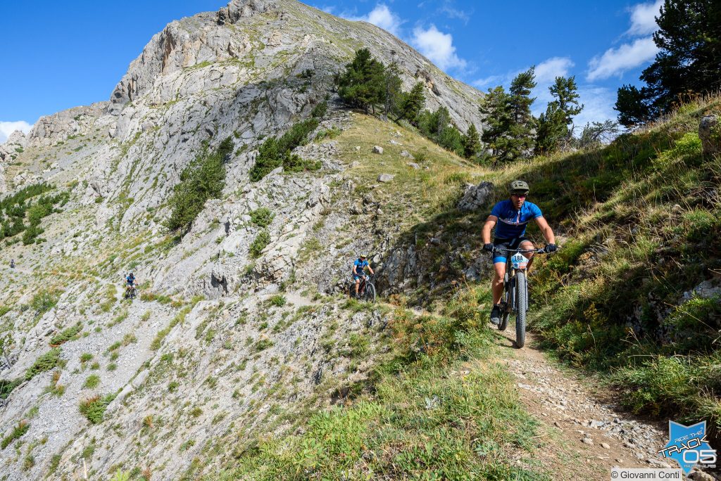 3 vététistes sur un sentier d'altitude à flanc de montagne